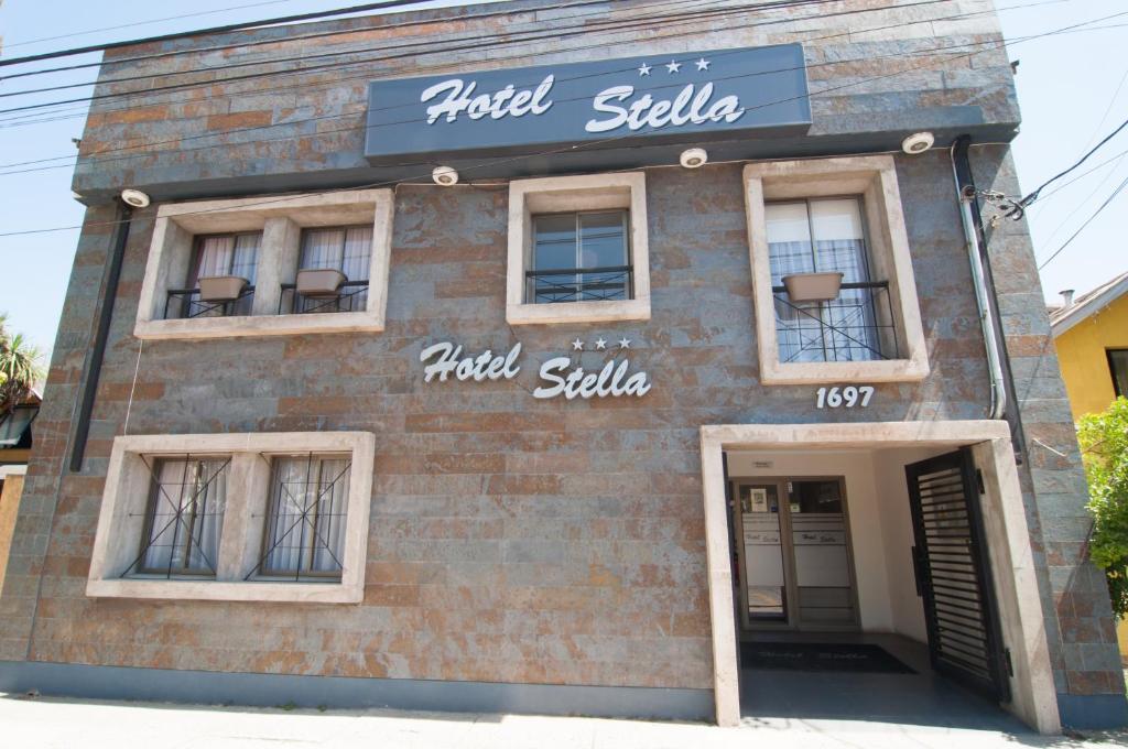 een bakstenen gebouw met ramen en een bord erop bij Hotel Stella Talca in Talca