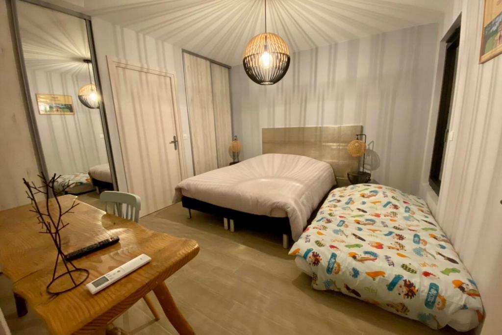 a bedroom with a bed and a desk and a table at Le Cottage proche du Golf in Panazol