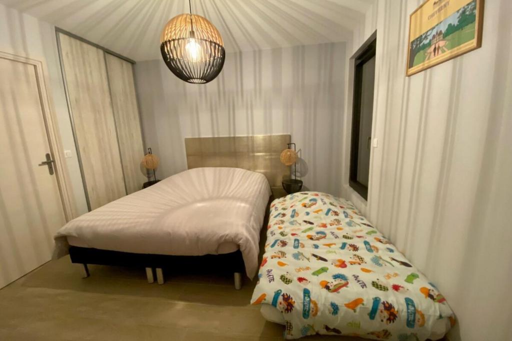 a bedroom with a bed and a bedspread on a bed at Le Cottage proche du Golf in Panazol