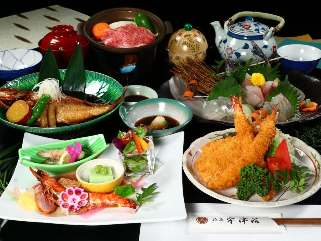 una mesa con platos de comida y tazones de comida en Uzueso en Tahara