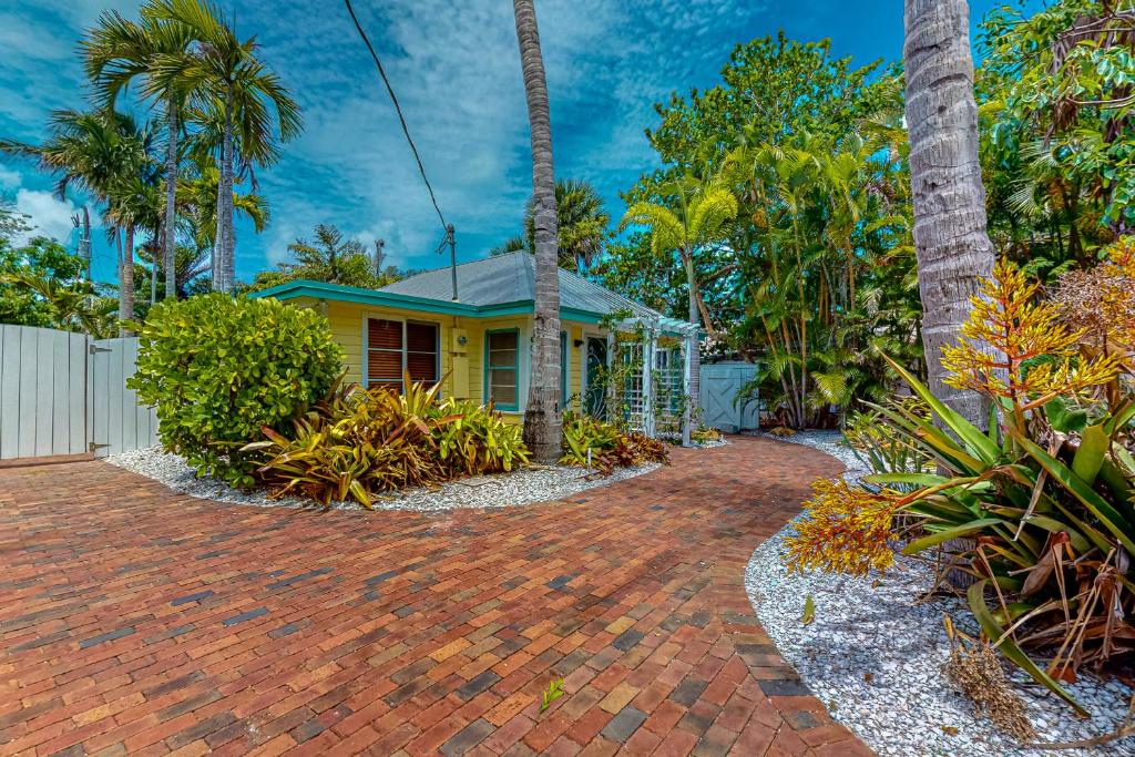 a house with palm trees and a brick driveway at The Wee Cottage in Anna Maria