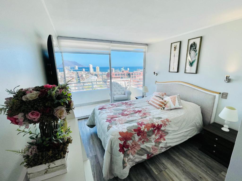a bedroom with a bed with flowers on it at Departamento con espectacular Ubicación, Vista al Mar y Panorámica a todo Iquique in Iquique
