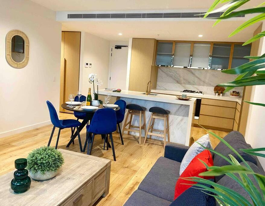 een keuken en een woonkamer met een tafel en stoelen bij So Unique! Collins Street Vibe 2B2B in Melbourne