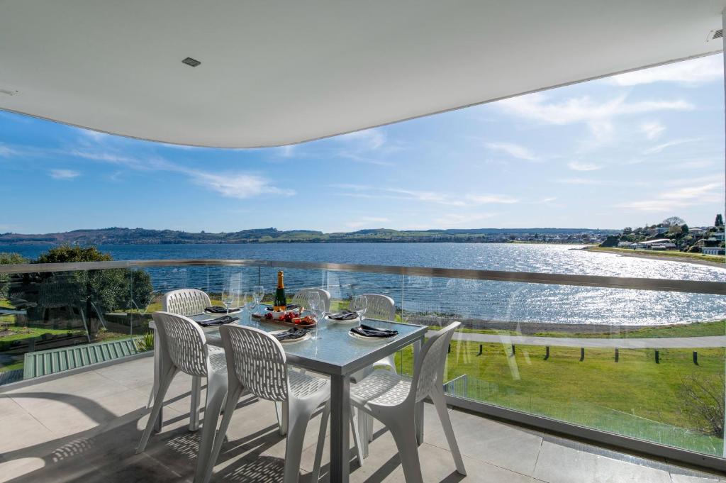 a dining room with a view of the water at Waimahana Apartment 8 in Taupo