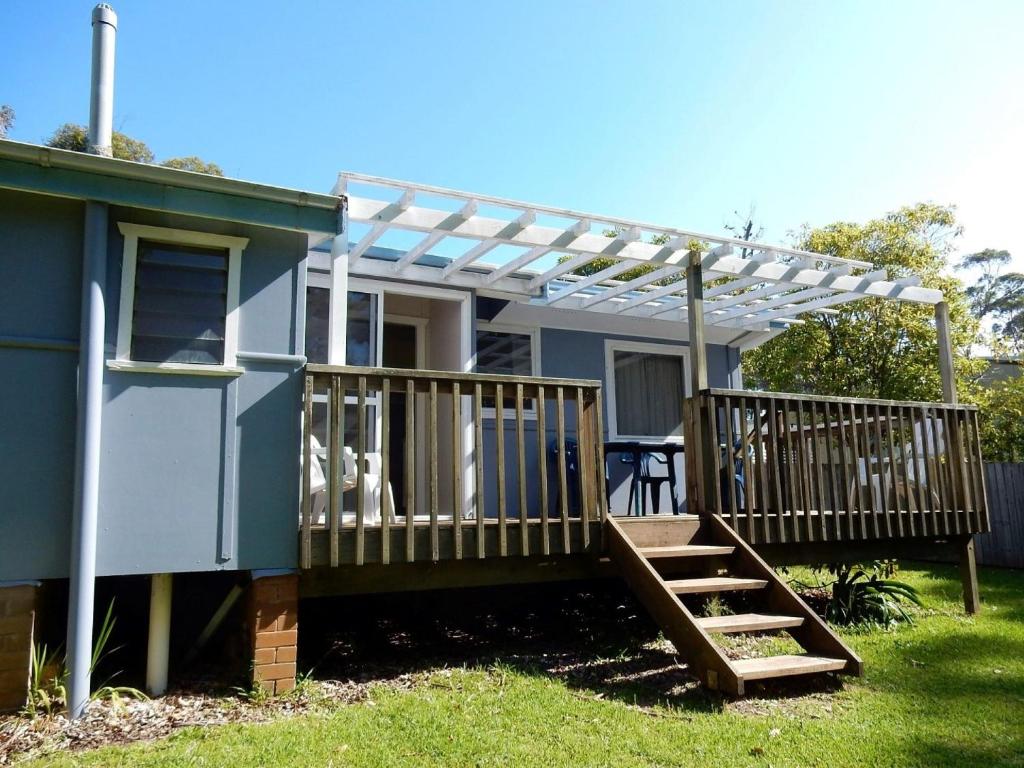 a house with a deck with a pergola at Donlan's Delight in Mollymook