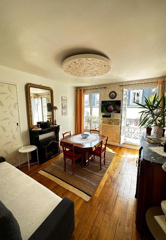 un salon avec une table et un piano dans l'établissement Appartement SAINTE ELISABETH - République, à Paris