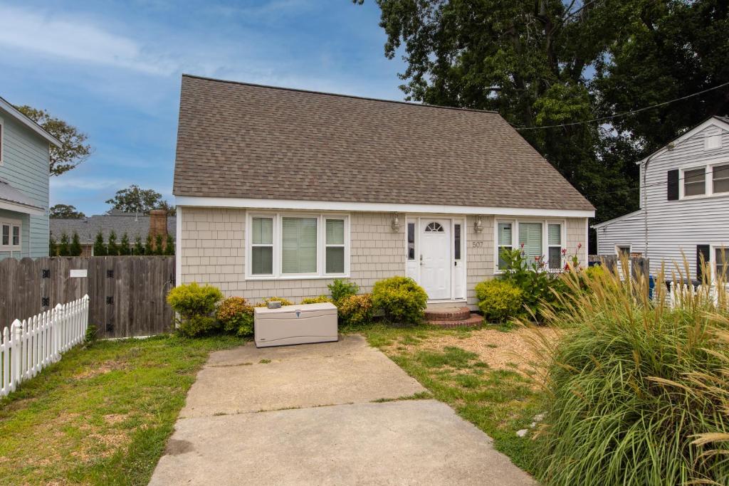 a white house with a fence and a yard at Sea La Vie in Virginia Beach