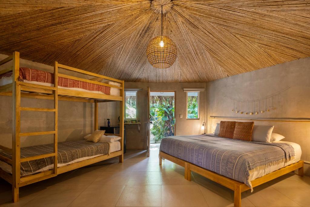 a bedroom with two bunk beds and a ceiling at Norte Nosara - Steps to Playa Guiones in Nosara