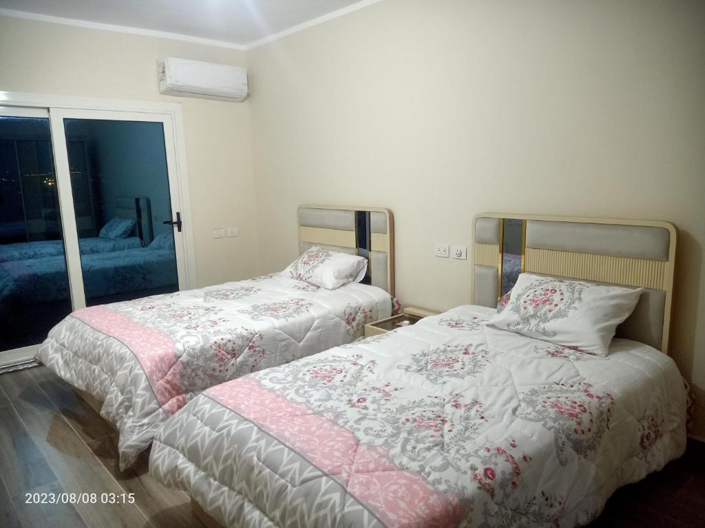 1 dormitorio con 2 camas y ventana en Down town new El alamein en El Alamein