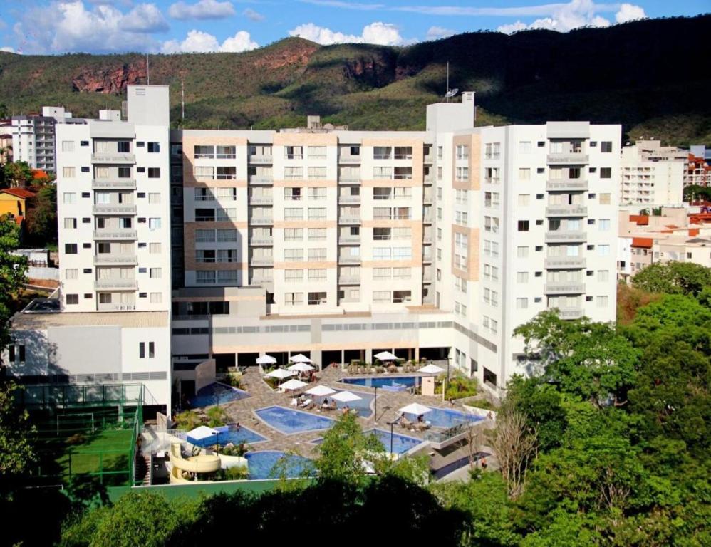 a large white building with a pool in front of it at HOTELParque Veredas flat 327 VISTA PARA PISCINA ASCESSO AO RIO AO LADO DO HOT PARK FABULOSO in Rio Quente