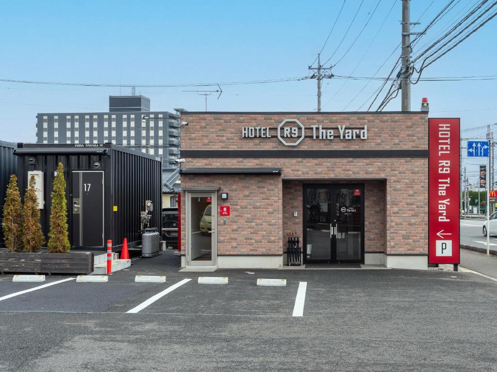 真岡市にあるHOTEL R9 The Yard Mokainterのホテルの消防車の前の駐車場