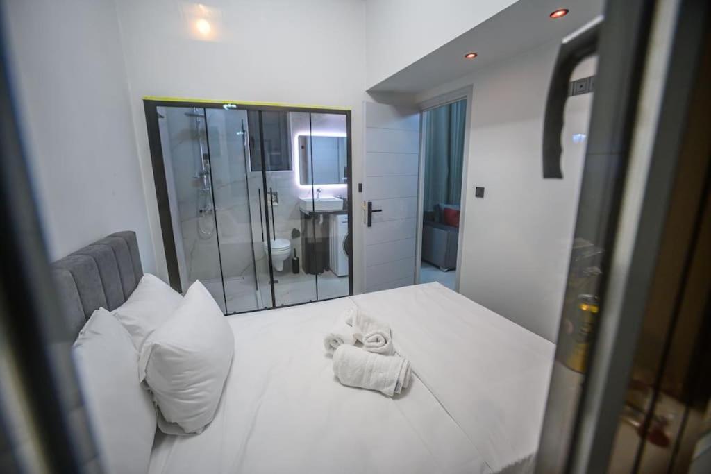 uma cama branca com uma toalha em frente a um espelho em Etheras Luxury apartment em Loutraki