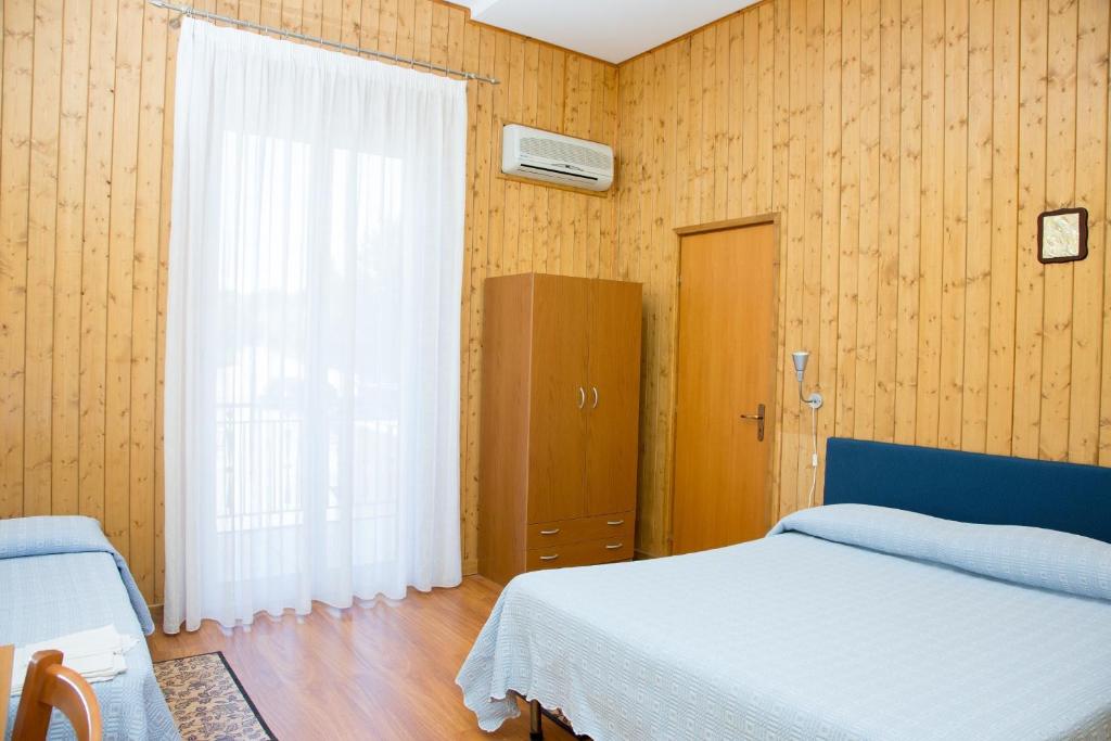 1 dormitorio con cama blanca y ventana en Terme Gorga Hotel, en Alcamo