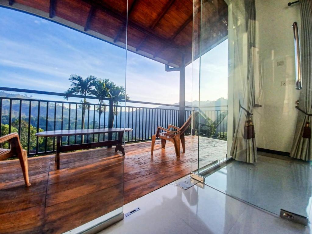 a room with a balcony with a view of the ocean at Ella Panorama Villa in Ella