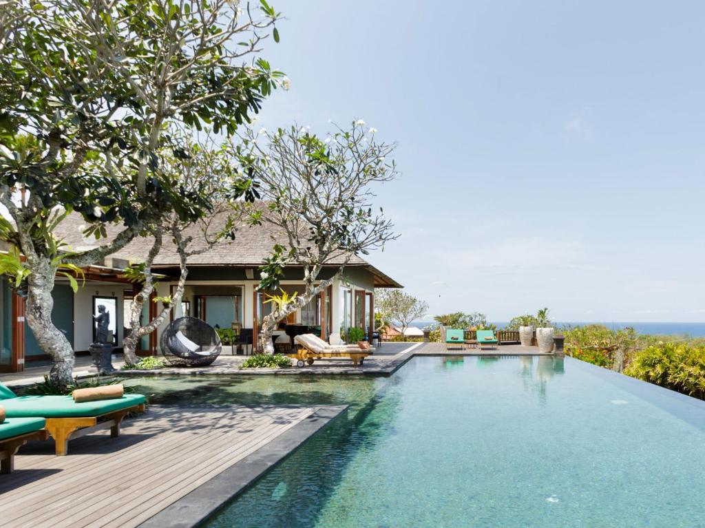 una piscina frente a una villa en The Shanti Residence by Elite Havens, en Nusa Dua