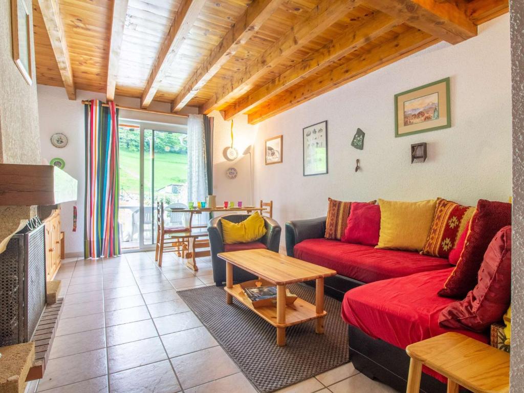 a living room with a red couch and a table at Maison Luz-Saint-Sauveur, 3 pièces, 6 personnes - FR-1-402-133 in Luz-Saint-Sauveur