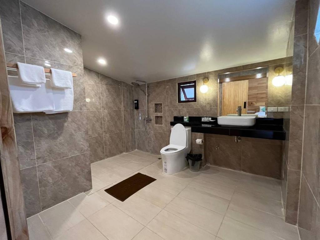 a large bathroom with a toilet and a sink at Palm Leaf Resort Koh Tao in Ko Tao