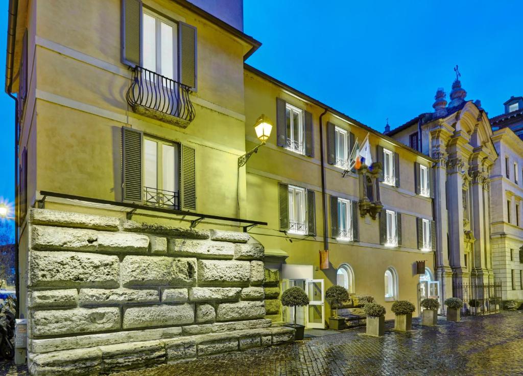 eine Reihe von Gebäuden in einer Kopfsteinpflasterstraße in der Unterkunft Hotel Indigo Rome - St. George, an IHG Hotel in Rom