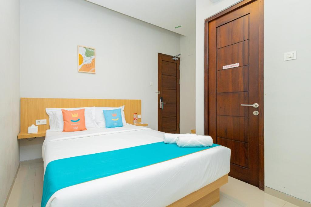 เตียงในห้องที่ Sans Hotel Bobosini Malang by RedDoorz