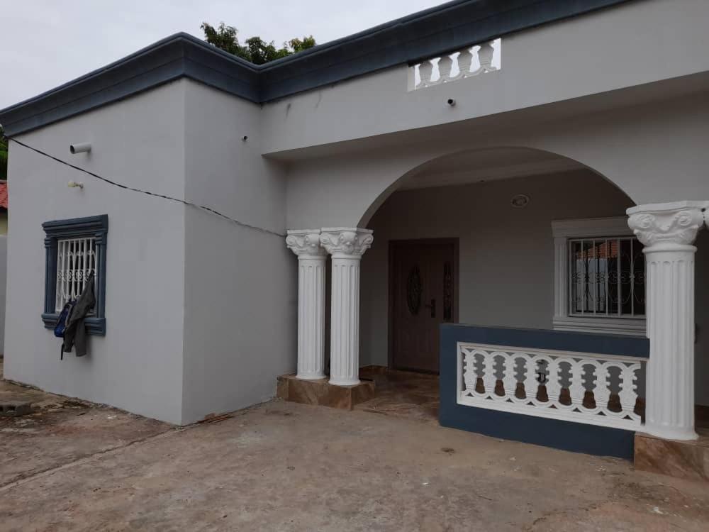 ein weißes Haus mit Säulen und einer Veranda in der Unterkunft Bijilo Villa in Bijilo