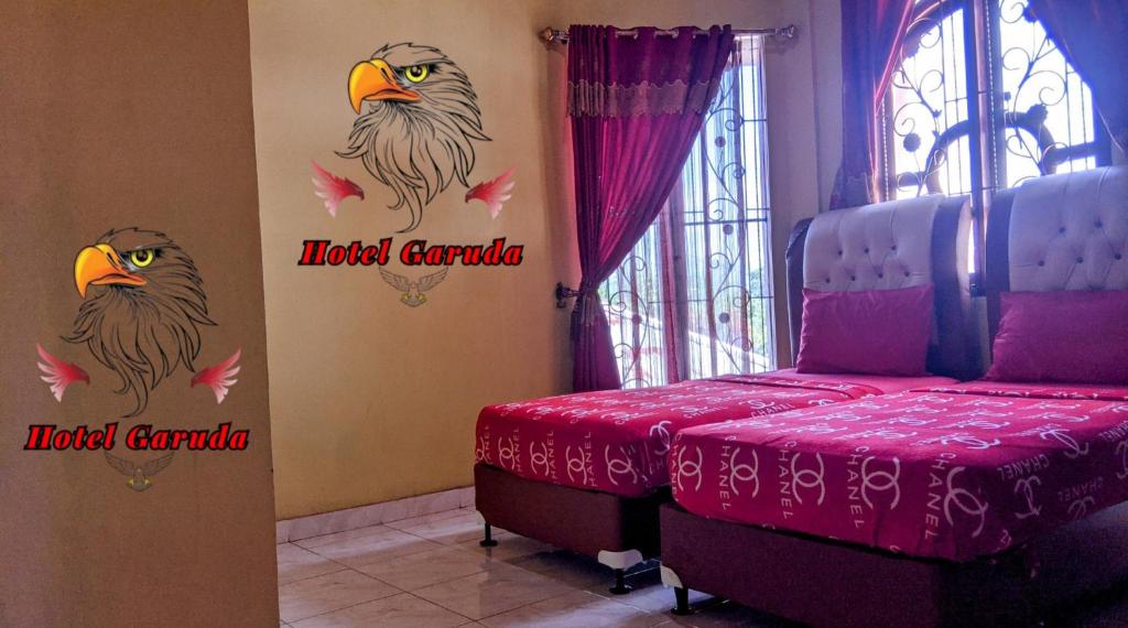 una camera da letto con due adesivi di gufo sul muro di Hotel Garuda a Rambah