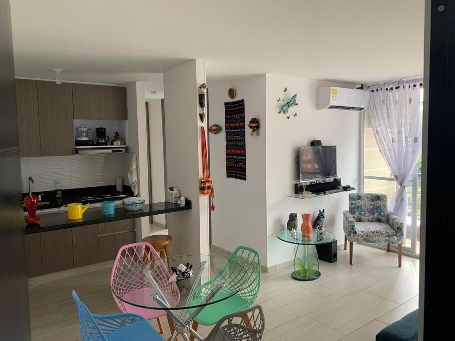 a living room with chairs and a table and a kitchen at Apartamento vacacional Girardot, in Girardot