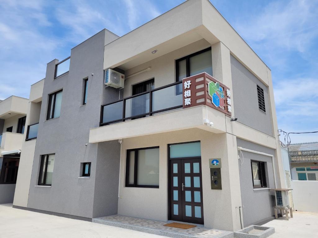 a large white building with a balcony at Penghu Good together Villa in Magong