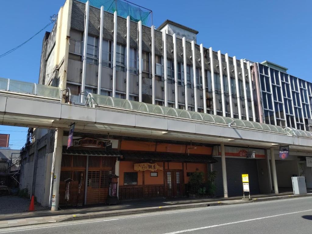 un edificio con un paso elevado frente a una calle en Taiya Ryokan en Fuji