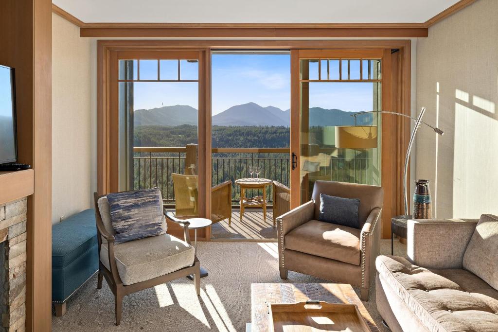 een woonkamer met een bank en stoelen en een balkon bij THE BEST at SUNCADIA LODGE - EXECUTIVE RIVER VIEW SUITE in Cle Elum