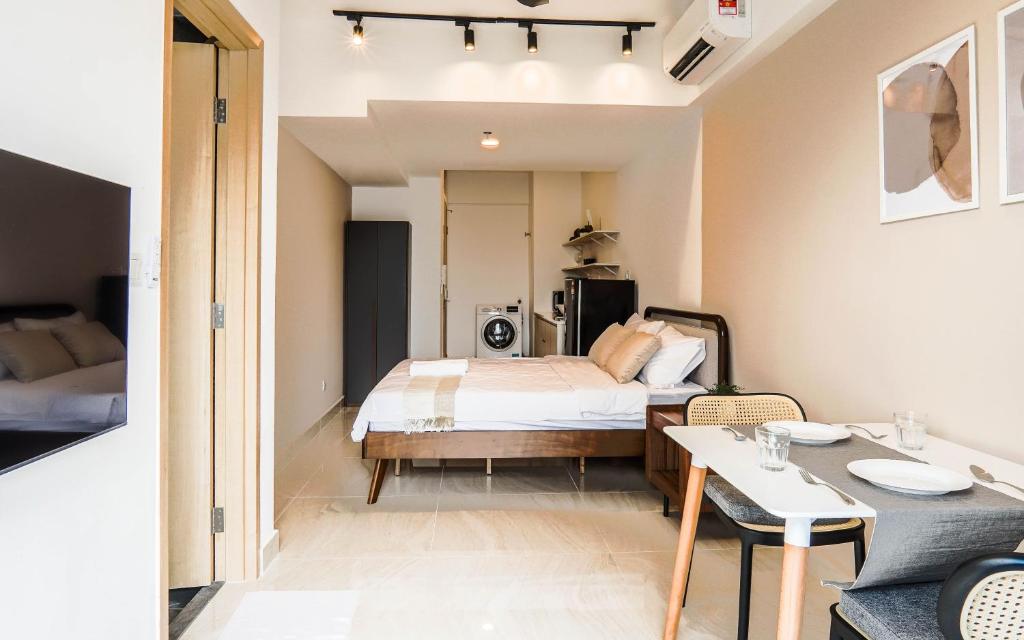 The Luxe Infinitum by Airhost في كوالالمبور: غرفة نوم صغيرة مع سرير وطاولة