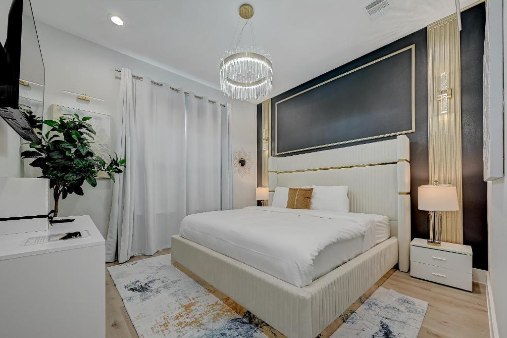 a bedroom with a white bed and a large screen at Victoria Island Palace Toyota Center Downtown Houston in Houston