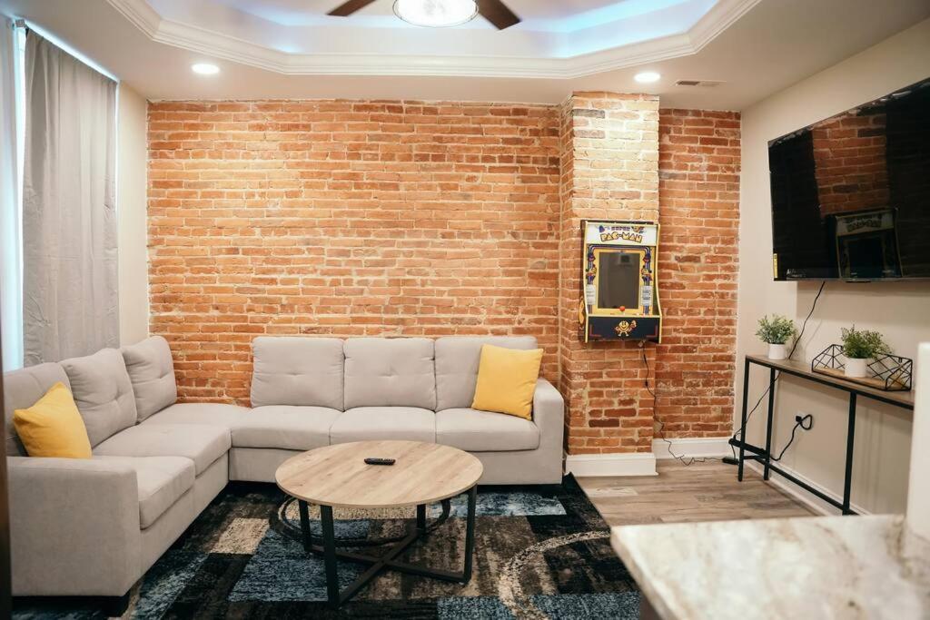 uma sala de estar com um sofá e uma parede de tijolos em Sleek and Cozy Micro Fells Point Residence! em Baltimore