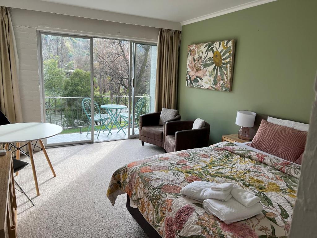 1 dormitorio con cama y vistas a un balcón en Riverbank Park MOTEL en Bright