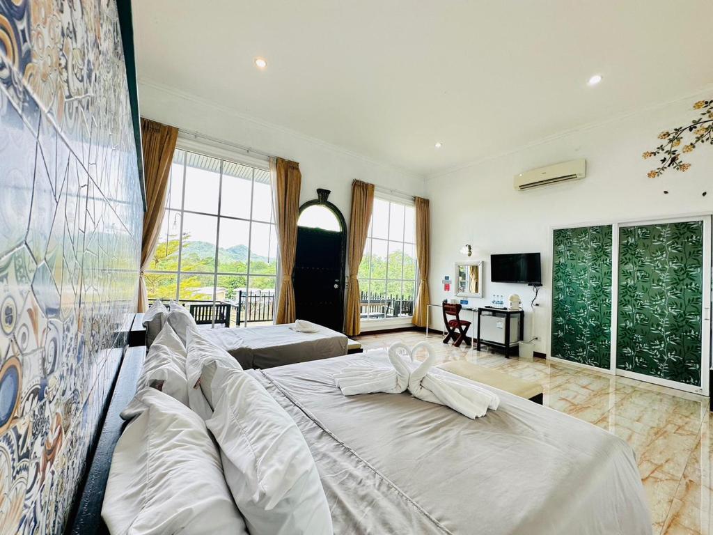 Yoko River Kwai Resort في ساي يوك: غرفة نوم مع سرير وغرفة معيشة