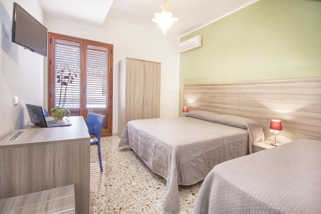 a hotel room with two beds and a television at B&B La Torre in Castellammare del Golfo