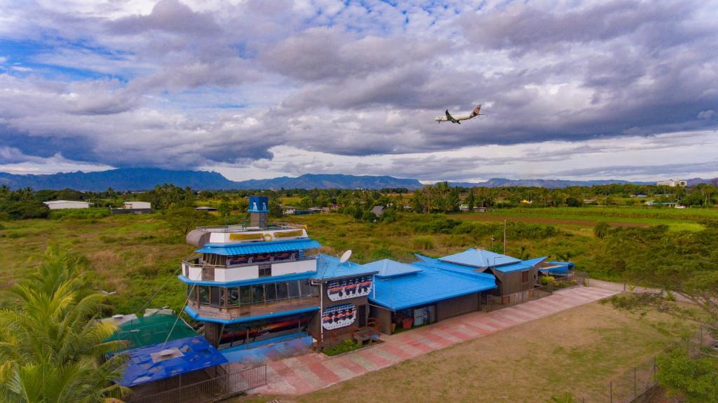 Ein Flugzeug fliegt über ein Gebäude mit einem Flugzeug. in der Unterkunft Tahals Holiday Villas in Nadi