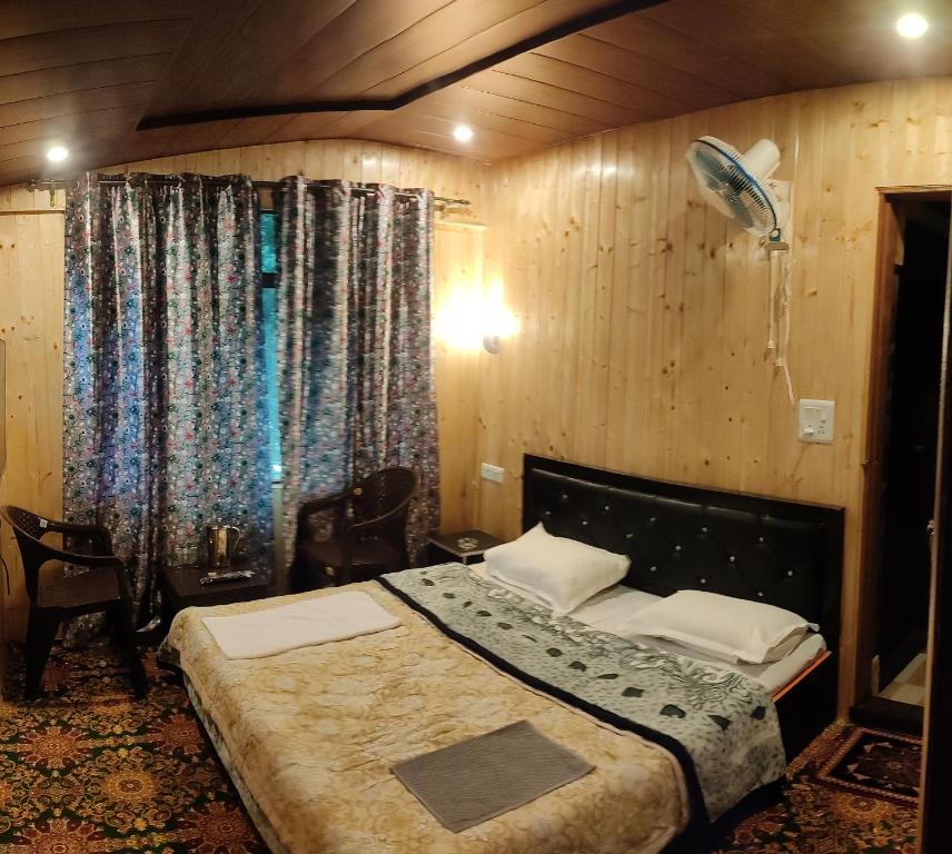 a bedroom with a bed in a room with curtains at Dream River Guest House in Pahalgām