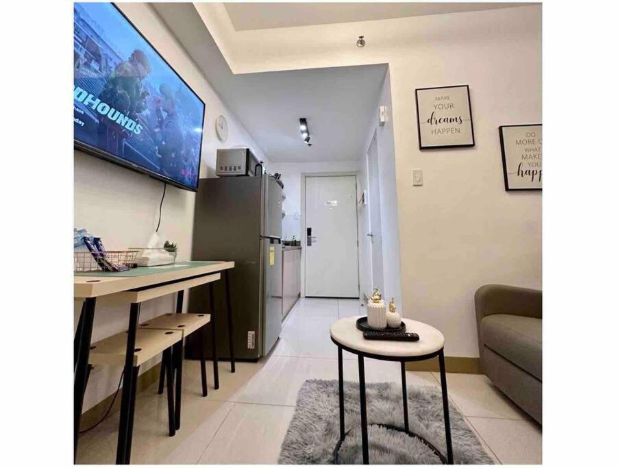 a living room with a couch and a table and a tv at 1 BR South Residences SM Southmall Netflix / Alexa in Manila