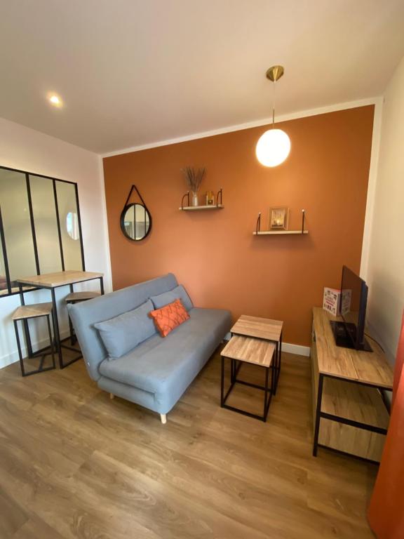 un salon avec un canapé bleu et une table dans l'établissement Petite échoppe Bordeaux, à Bègles