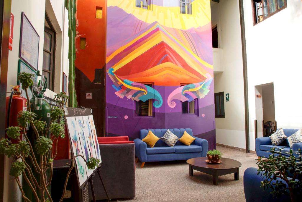 una habitación con sofás y una pintura en la pared en Bear Packer Hostel, en Cusco