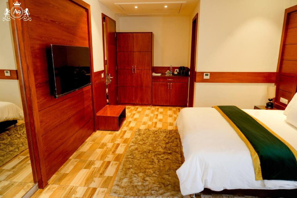 a hotel room with a bed and a flat screen tv at Hotel A9 Barnala in Barnāla
