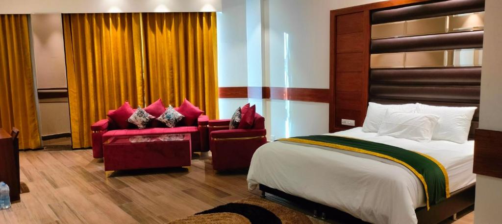 a hotel room with a bed and two chairs at Hotel A9 Barnala in Barnāla