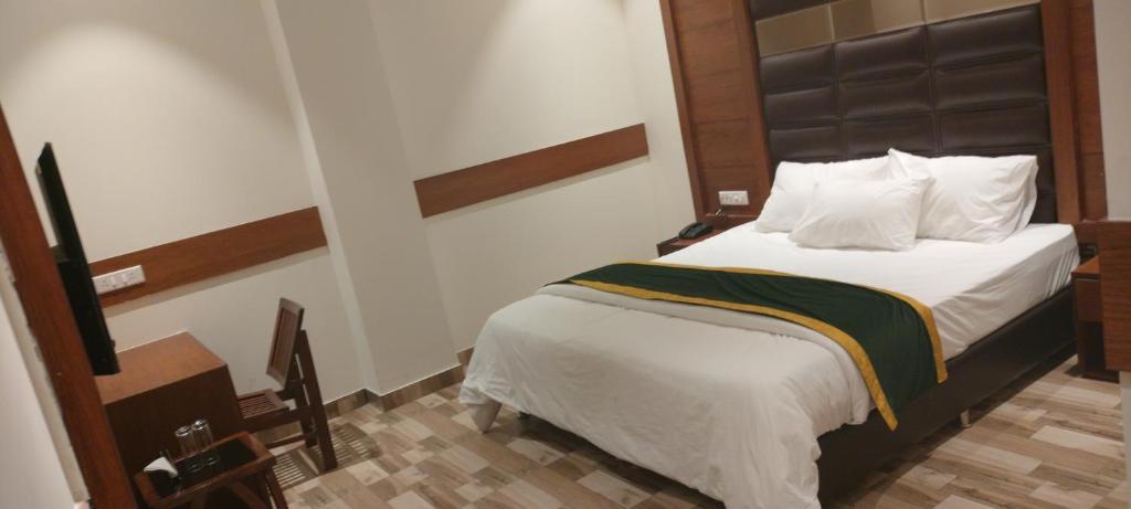 a bedroom with a large bed with a black headboard at Hotel A9 Barnala in Barnāla