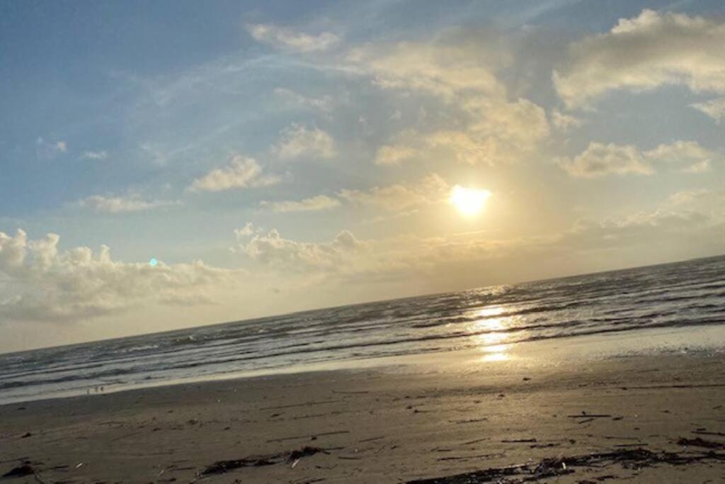 a beach with the sun rising over the ocean at Cozy Coastal Condo in Corpus Christi