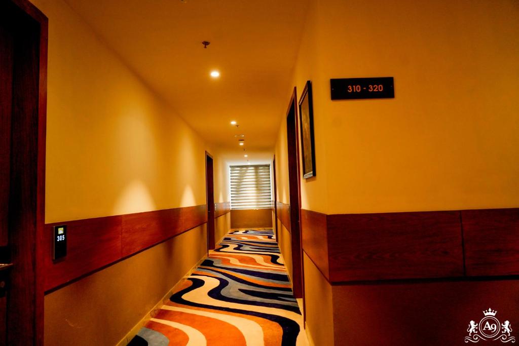 a hallway with yellow walls and a striped carpet at Hotel A9 Barnala in Barnāla