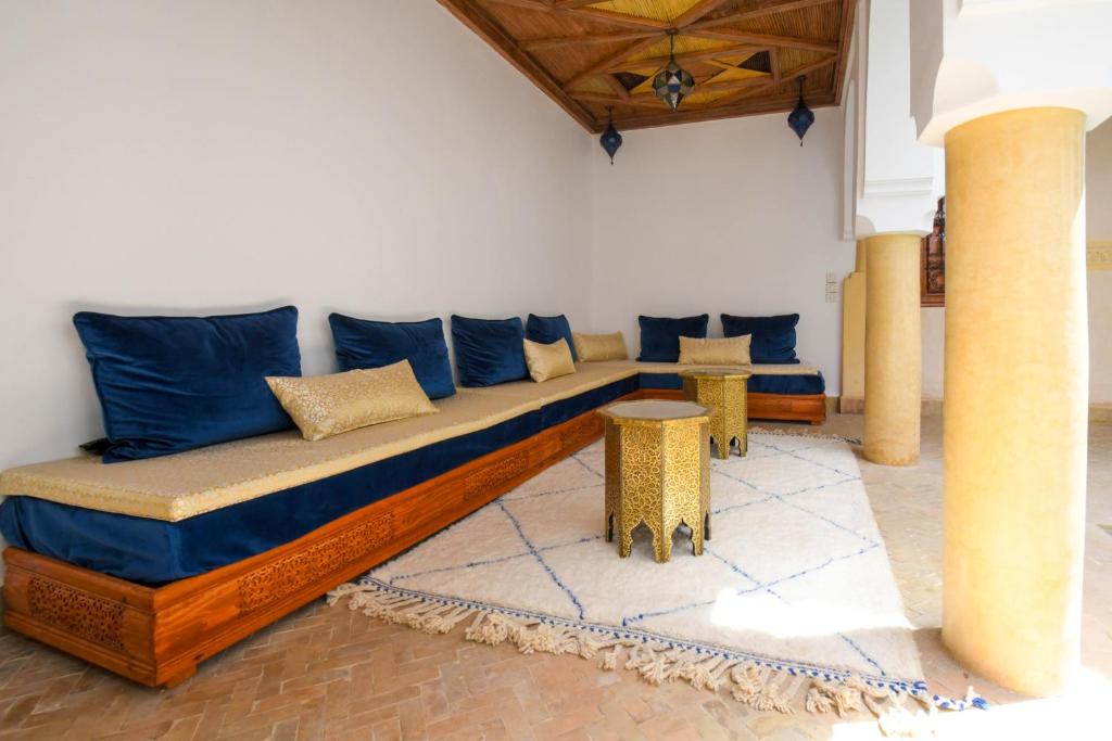 a couch with blue pillows in a room at Riad Berenssi in Marrakesh