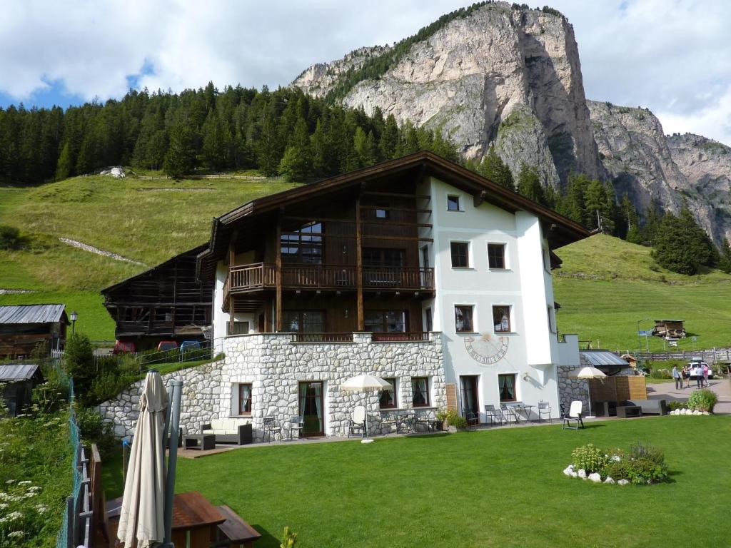 um grande edifício com uma montanha ao fundo em Cedepuent de Sot em Selva di Val Gardena