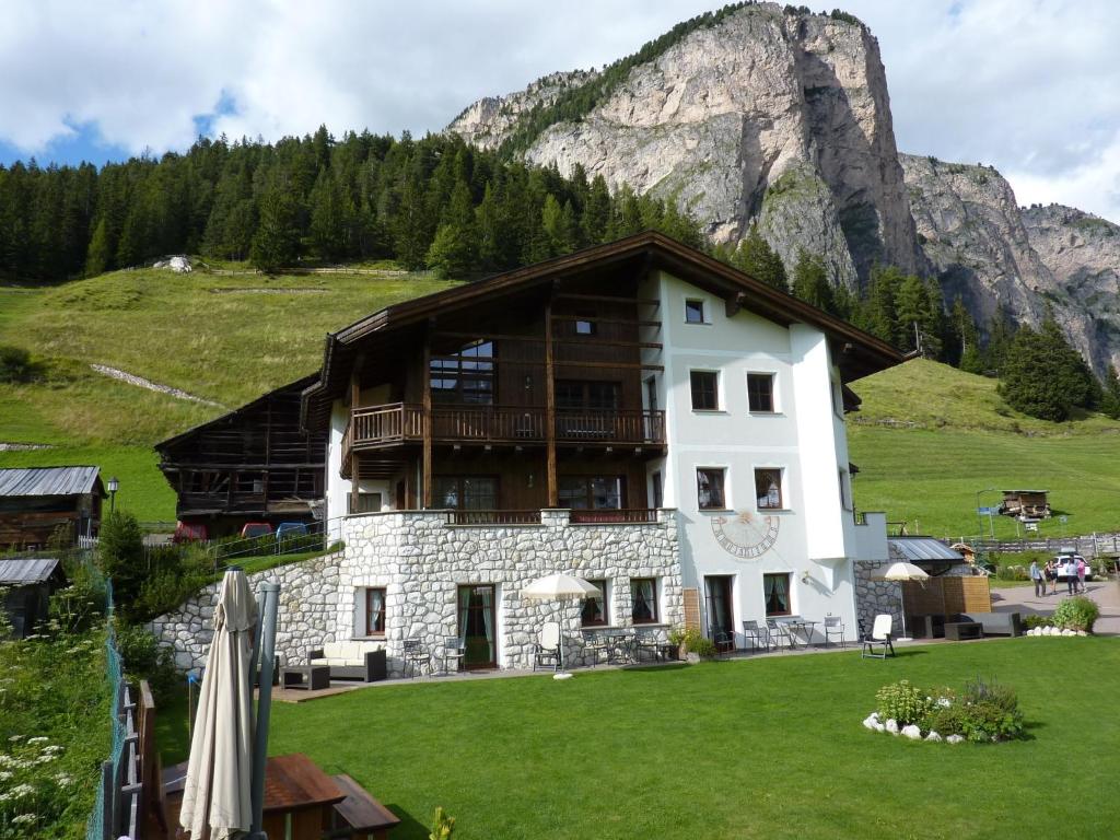 a large building with a mountain in the background at Cedepuent de Sot in Selva di Val Gardena