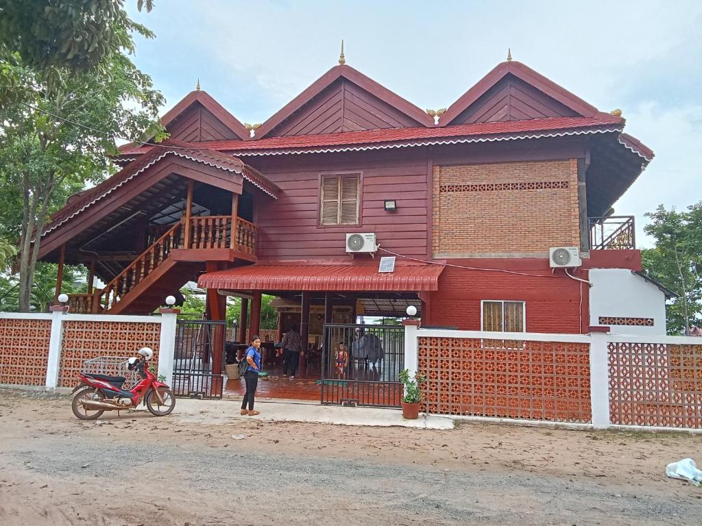 una casa con una motocicleta estacionada frente a ella en Domnak Teuk Chhou, en Kampot