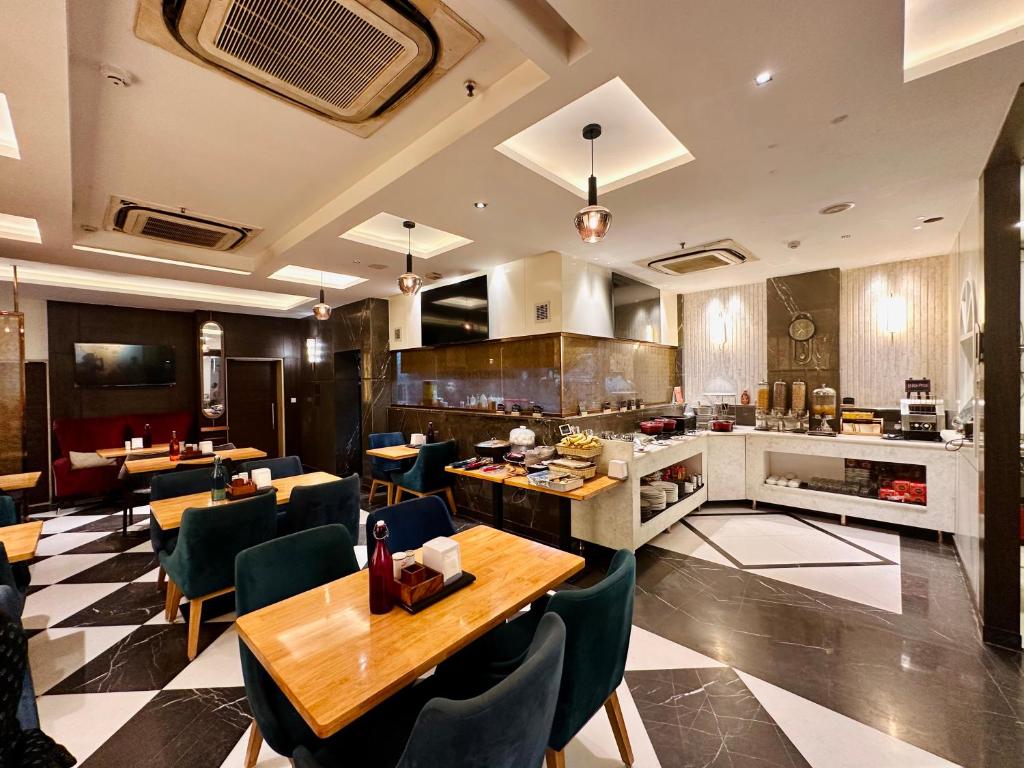 un restaurante con mesas y sillas y una cocina en THE SINGH EMPIRE, New Delhi en Nueva Delhi